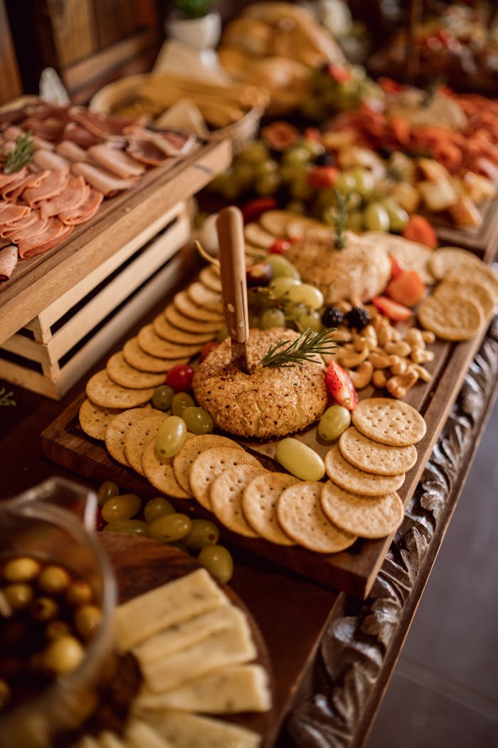 A beautifully arranged grazing table featuring cheeses, cold meats, fruits, and crackers.